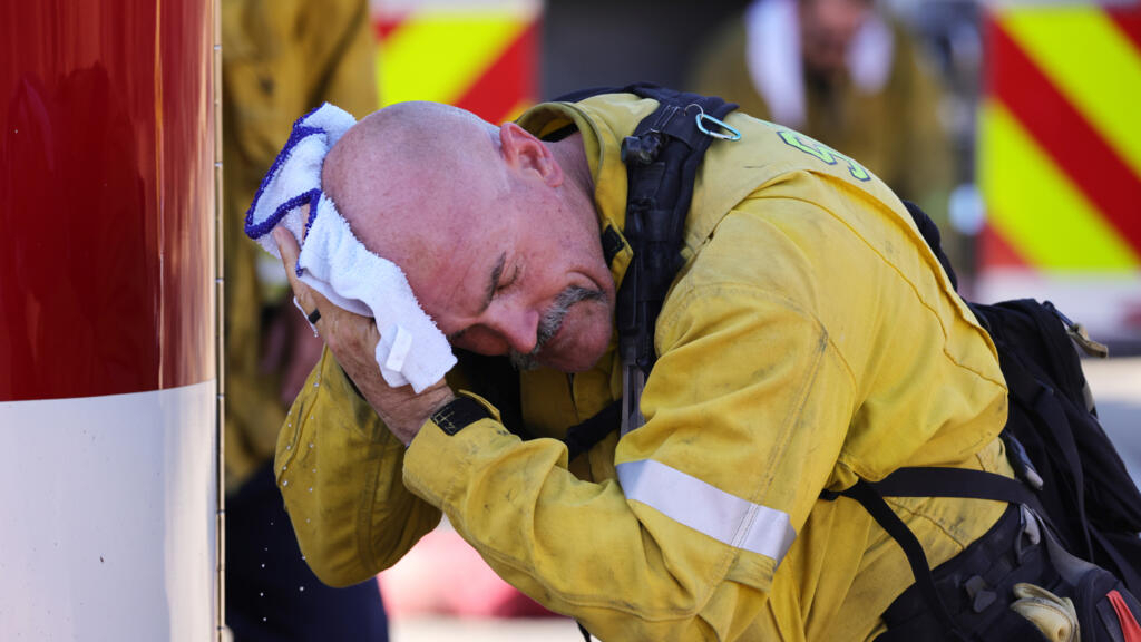 Un bombero del condado de San Bernardino se limpia la cabeza mientras arde el Incendio Oak cerca de Fontana, California, el 20 de julio de 2023