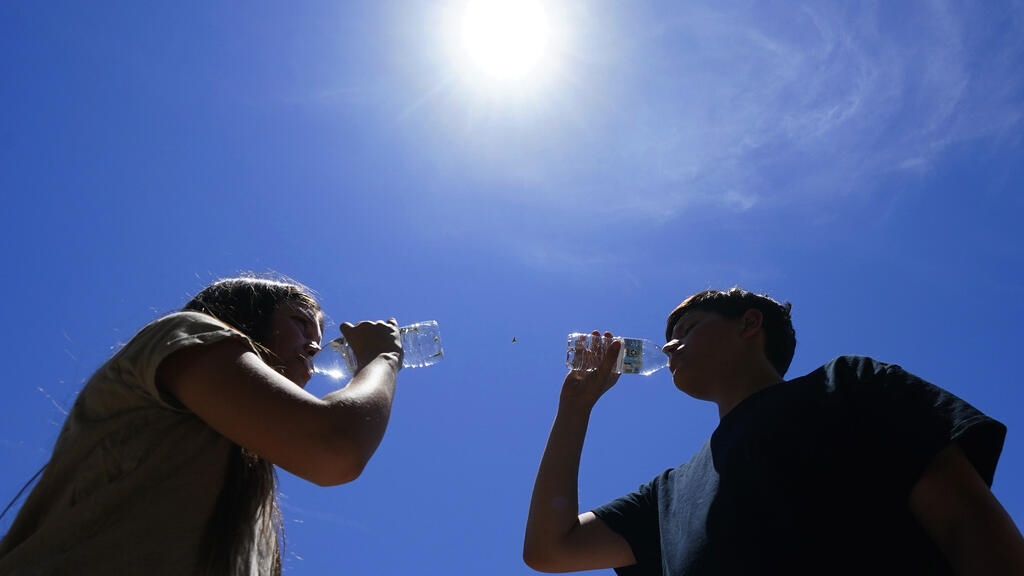 Jóvenes tomando agua en Phoenix, Arizona, julio de 2023.
