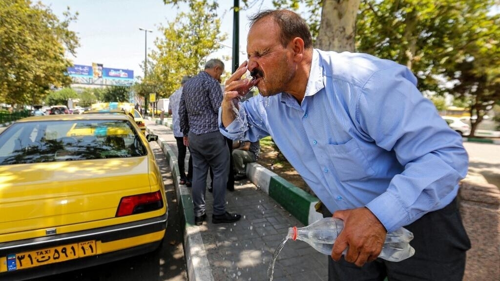 Un hombre se hidrata en Teherán, julio de 2023.
