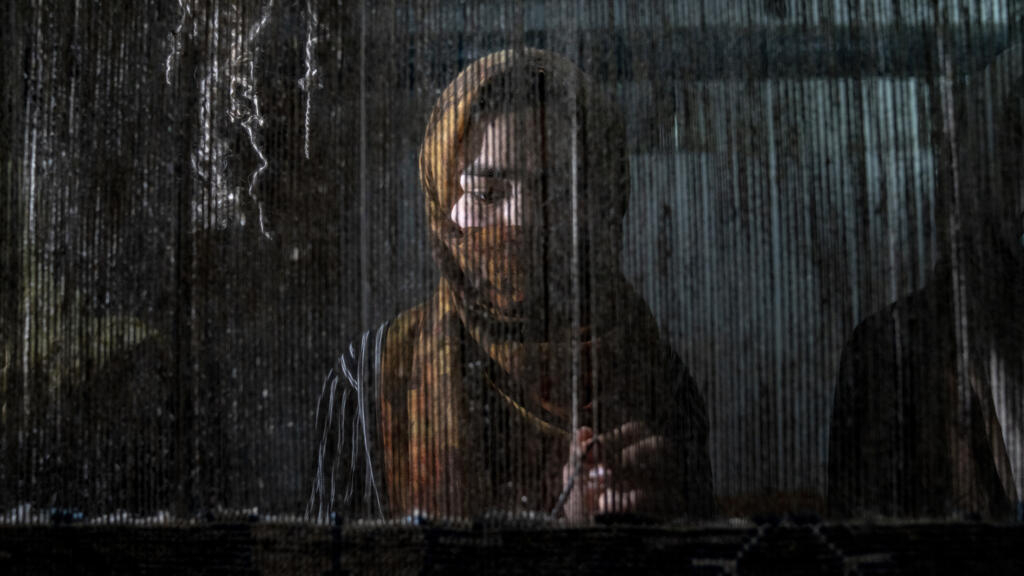 Desde diciembre, las mujeres afganas tienen prohibido trabajar en muchos sectores y universidades, lo que las limita al hogar o a trabajos manuales. Aquí, una mujer afgana teje una alfombra tradicional en Kabul el 6 de marzo de 2023.