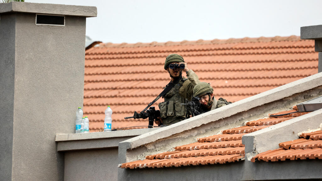 Soldados israelíes observan entre edificios, mientras aumenta la violencia en torno a la cercana Franja de Gaza tras un ataque masivo de infiltrados palestinos armados, en Sderot, sur de Israel, 9 de octubre de 2023.