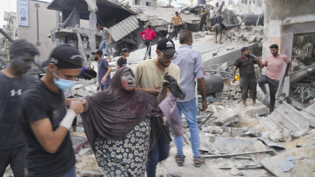 Palestinos evacúan edificios tras los bombardeos israelíes en Deir al-Balah, Franja de Gaza, 22 de octubre de 2023.